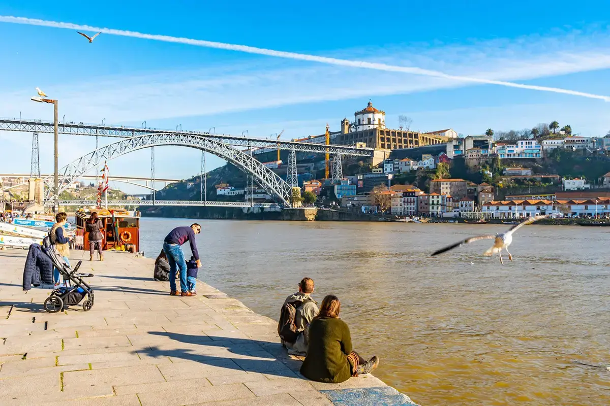 People sitting by the Ribeira, in Porto, enjoying a winter morning.