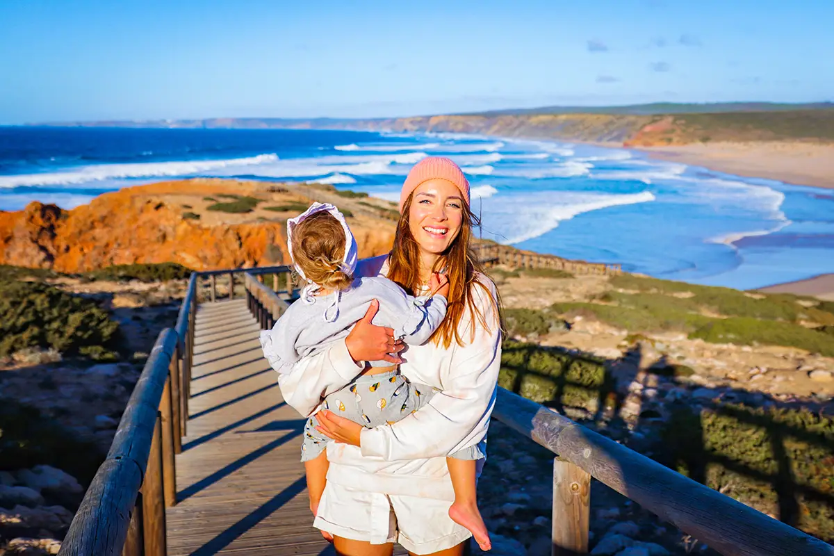 U.S. citizen holds her baby happily on a Portuguese beach in the Algarve.