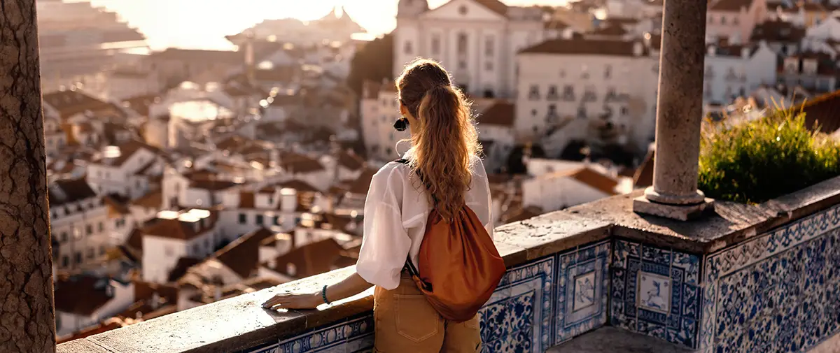 Foreign resident in Portugal admiring the cityscape from one of Lisbon's viewpoints. 