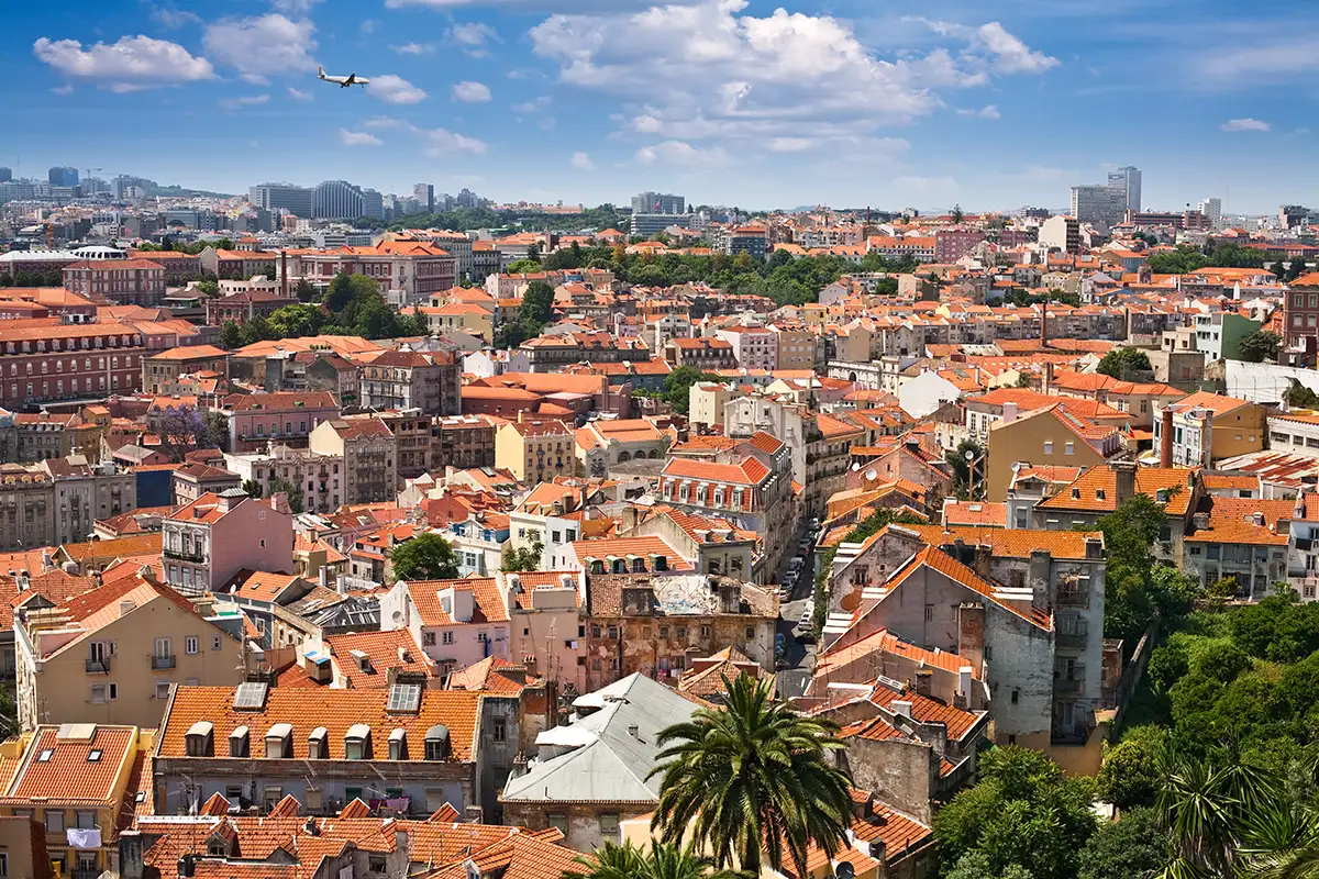 Skyline of Lisbon city centre with a US - Portugal connection plane above.