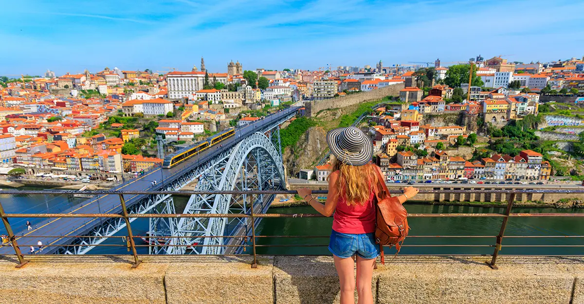 An expat woman admires the Luís I Bridge and the Douro River, iconic sights of the Porto riverside, in Portugal.